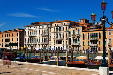 Obraz premium Motor boats parking in Grand Canal in Venice on background of impressive architecture of ancient buildings on banks of canal