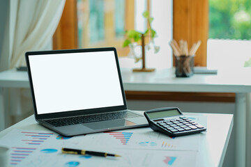 Fototapeta premium Business ideas, documents, financial graphs, and laptop computers with calculators on the desk.