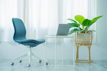 Interior architecture, design, workstation, home office with steel table and adjustable chair, laptop, computer, notebook, decorated with plant baskets, flower pots.