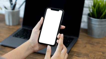 Hands of a woman using a  smartphone mockup at his desk. Mobile phone blank screen for editing graphics.