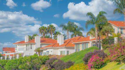 Panorama White puffy clouds Residential homes with orange bricks roofs and palm trees at Sou