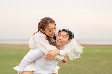 Happy young Asian couple in bride and groom clothing