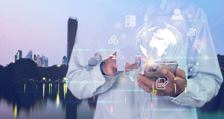 Businessmen use smartphones to transact online, connect to the world, search big data, background, capital city view at night.