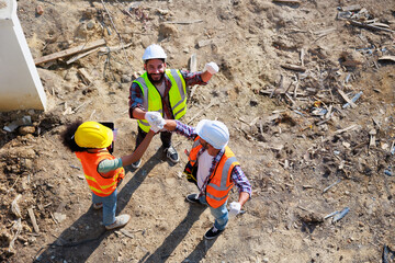 Hand together top view. Successful teamwork unity. Mechanical Engineer and construction team at house project underconstruction site. Hands meeting together