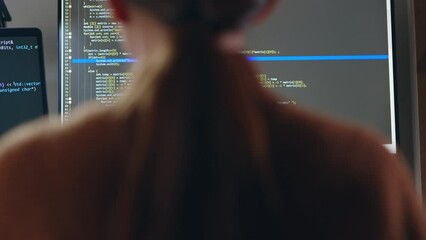 Young Asian woman, developer programmer, software engineer, IT support, wearing glasses working hard at night overtime on computer to check coding in bugging system. Back view - Powered by Adobe