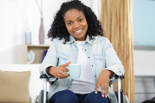 smiling woman in a wheelchair drinking coffee