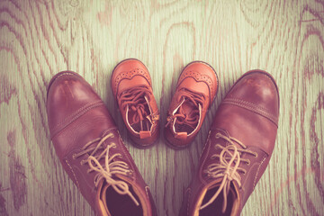 Still life with boots or brown shoes of daddy and son on on wooden table,fathers day