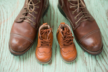 Still life with boots or brown shoes of daddy and son on on wooden table,fathers day