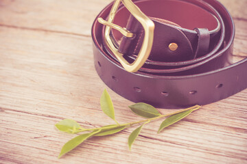Brown belt on rustic wooden background.