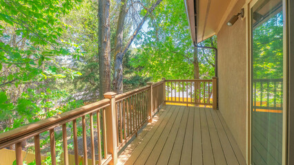 Panorama Wooden deck of a house with a view of trees outside