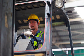 Warehouse male staff driving forklift in warehouse factory. Worker wearing vest and protective hard hat. Industrial and industrial workers concept