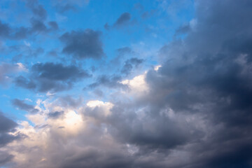 Naklejka na ściany i meble White and black clouds in the blue evening sky.