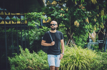 Portrait of a fashion young man at beautiful green leaves background in jungle