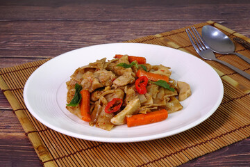 Thai style spicy rice noodle with chicken or Drunken rice noodle with chicken, famous Thai food. Selective focus, copy space