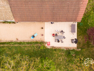 Vue aérienne d'une maison avec jardin et terrasse. Vue aérienne d'une famille sur une terrasse. 
