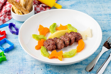 Turkish meatball traditional kofte. with carrots and zucchini cut into animal shapes. Spicy Meatballs Kebab or Kebab