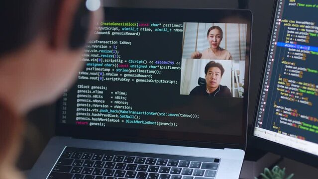 Asian woman developer programmer, software engineer, IT technical support center talking with team via video call. Working on computer overtime to check coding in bugging system.