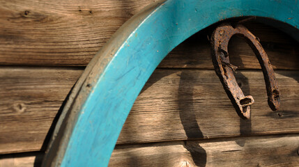 A rusty horseshoe and harness hanging on a wooden wall