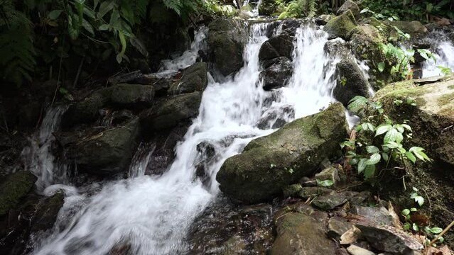 Close-up shot of a waterfall cascading down a rock in slow motion, laterite palace