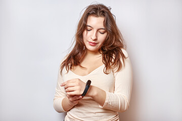 Naklejka premium Girl with a fitness bracelet on her arm. Modern gadgets and digital technologies in human life.