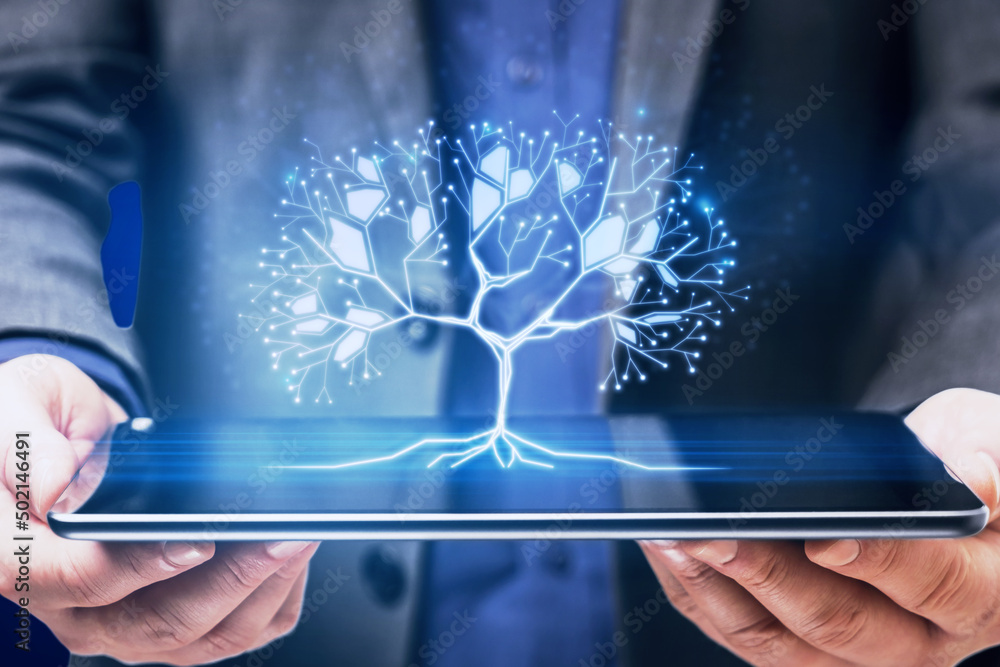 Poster close up of businessman hand holding tablet with glowing digital polygonal tree on blue background. 