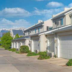 Square White puffy clouds Attached garages of townhouses with concrete driveway at Daybrea