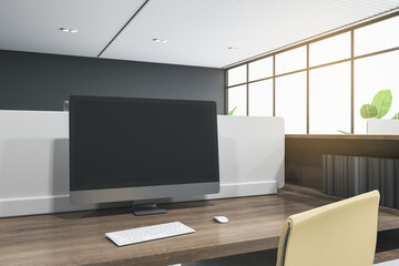 Close up of blank computer monitor in coworking office interior with wooden desk and bright city view. Mock up, 3D Rendering.