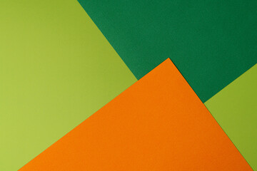 Colorful overlapped orange and green cardboard layers of paper on background, top view