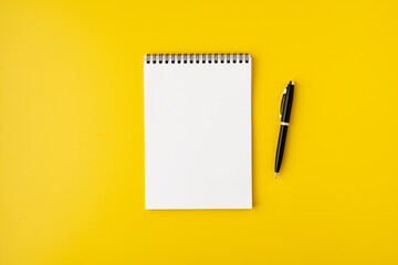 Blank spiral notebook with fountain pen on colorful yellow background, top view, copyspace