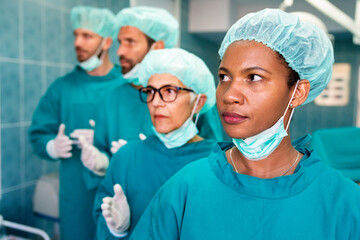 Portrait of successful team of surgeon standing in operating room, ready to work