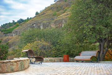 Street benches in a picturesque place of the park near the hill