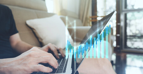 Man hand typing laptop keyboard with bullish financial stock graph profit increase