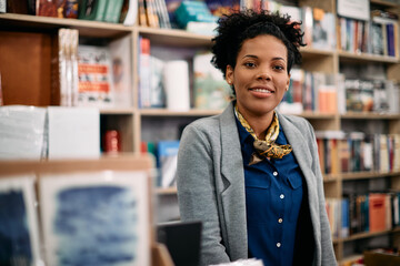 Portrait of happy black bookstore owner looking at camera.