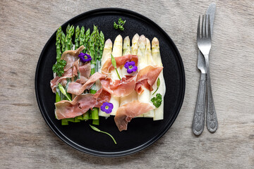 White and green asparagus with prosciutto ham and sauce. Great seasonal food, easy cooking meal for keto diet dinner or lunch.