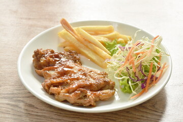 grilled chicken black pepper steak dressing spicy sauce with French fries and salad on plate