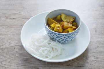 boiled spicy mackerel fish entrails with vegetable curry soup Thai southern style food and rice noodles on plate