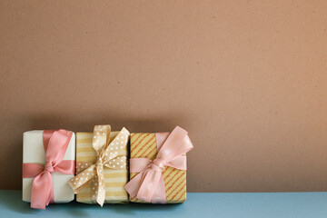 Gift boxes on blue table. brown wall background