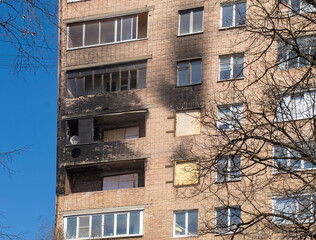 A section of the wall of a residential brick building with traces of a fire that affected three apartments