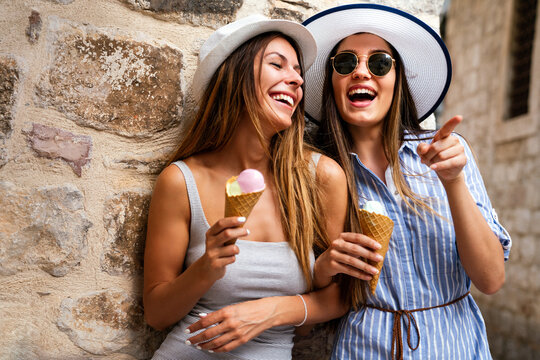 Happy young women friends enjoying ice cream together on summer vacation