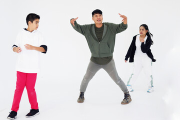 Asain young professional dancer and teacher is break dancing with students on white background in dance class at studio. Education and sport for hobbies of kids concept