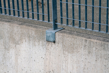 the fence with stainless steel electro-welded metal grid. detail of the bracket that is fixed with the prefabricated concrete base.