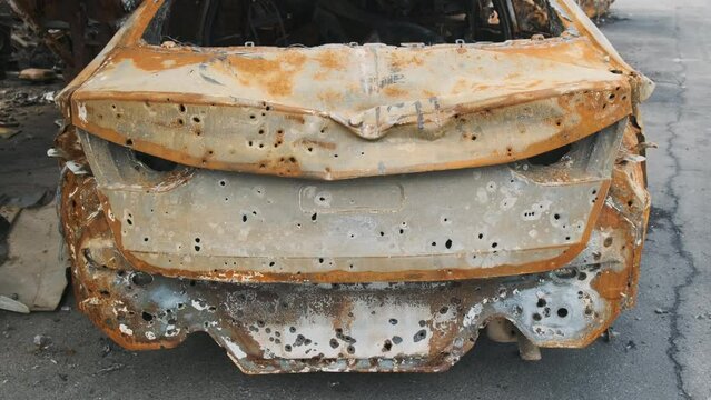 Irpin, rusty shelled car, the aftermath of the Russian army's invasion of Ukraine. War in Ukraine