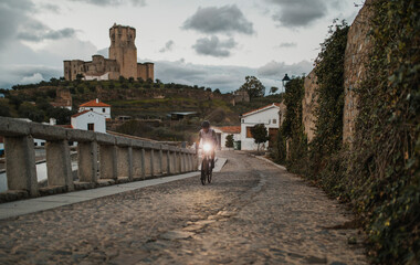 Cyclist riding bicycle on cobble stone road