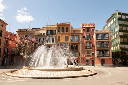 Spain, Balearic Islands, Palma, Traffic circle fountain with row houses in background