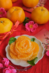 Obraz na płótnie Canvas The auspicious and iconic fruit of Chinese New Year. Flower Patterned Peeled Mandarin Slices. Only flower pattern in focused with blurry mandarin oranges in background