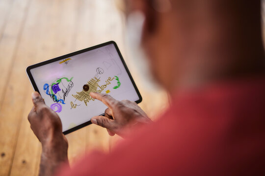 Man Drawing On Tablet PC At Home