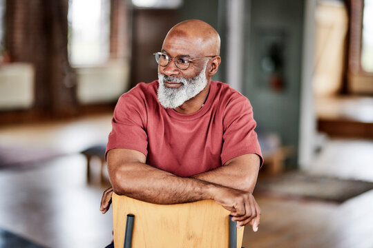 Man with eyeglasses contemplating on chair at home