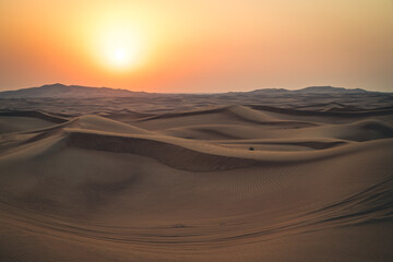 Fototapeta na wymiar Sonnenuntergang in einer Wüsten- und Dünenlandschaft in Dubai in den Vereinigten Arabischen Emiraten