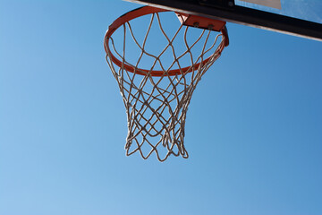 Old basketball goal against the blue sky, rear view, close-up