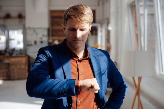 Businessman looking at hand standing in office